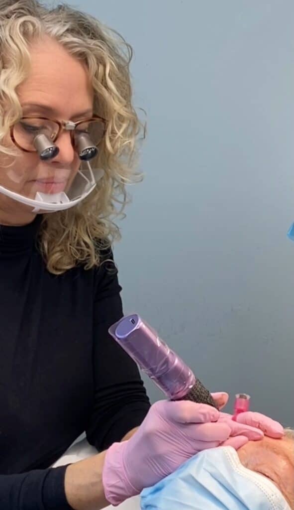 Permanent makeup-artist i gang med tatovering af øjenbryn på kunde